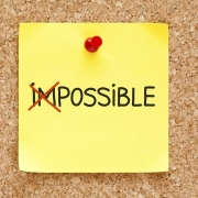 The word Impossible turning into Possible on yellow sticky note.