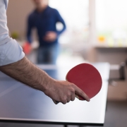 two men playing ping pong in an office