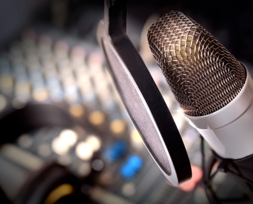 Recording equipment in studio. Studio microphone with headphones and mixer background