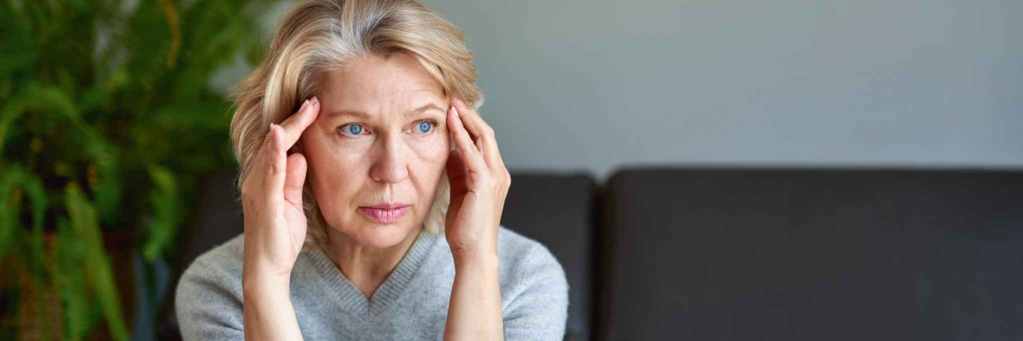 grey divorce mediation--older woman holding head in sadness